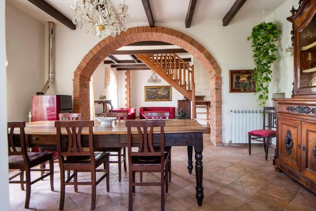 une salle à manger avec une table et des chaises en bois dans l'établissement Villa Tuscan Prestige 25 ospiti Piscina Jacuzzi, à La Croce