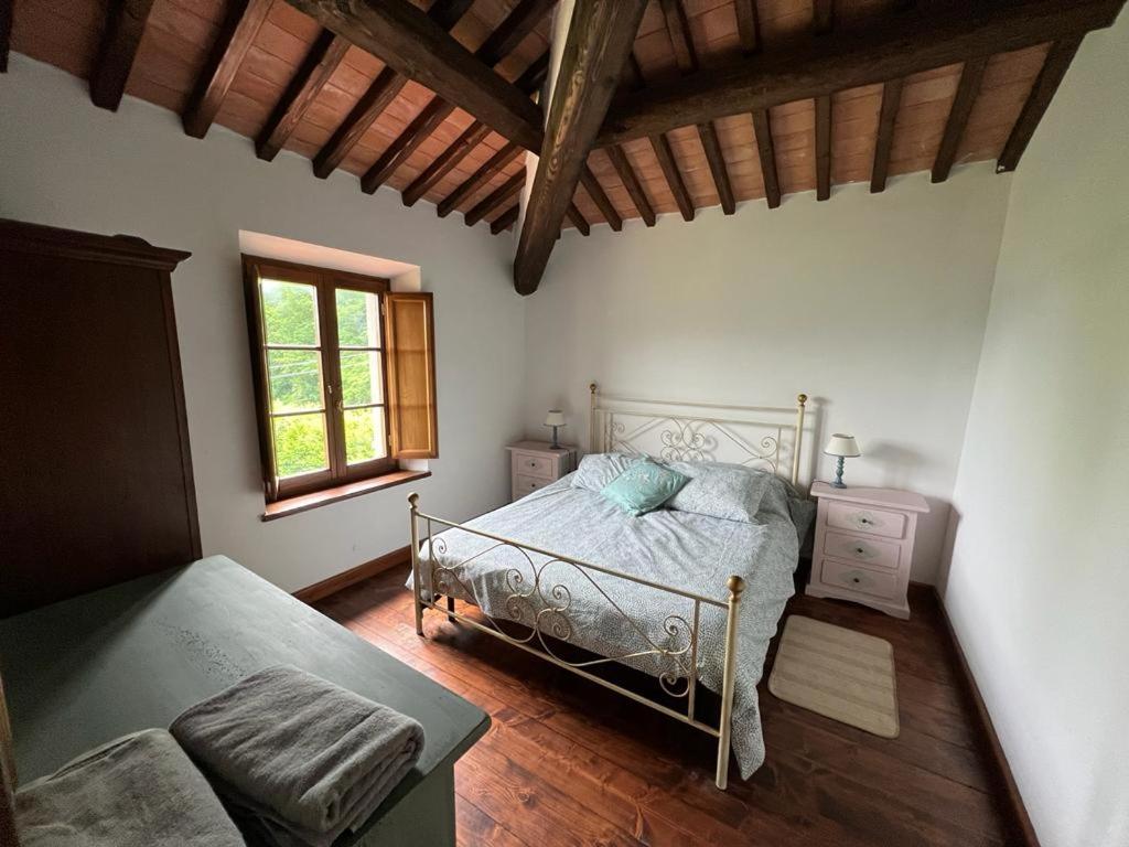 une chambre avec un lit et une fenêtre dans l'établissement Villa Casa di Pietra en el norte de Lucca, Toscana, à Camporgiano