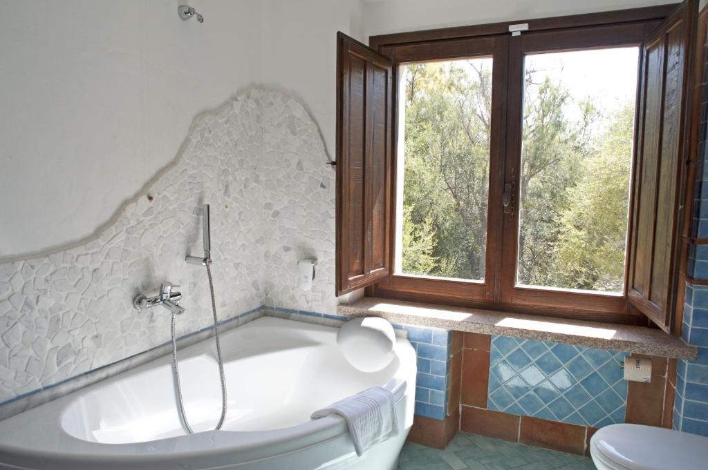 une baignoire dans une salle de bain avec une fenêtre dans l'établissement Nascar Hotel, à Santa Maria Navarrese