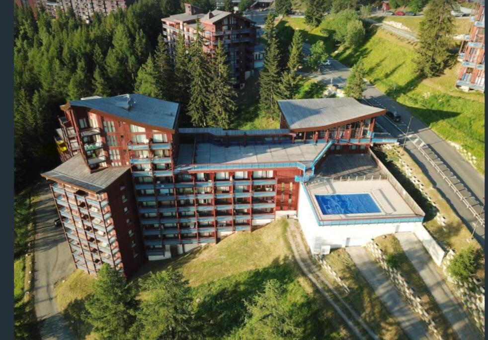 une vue aérienne d'un immeuble avec piscine dans l'établissement RESIDENCE LE RUITOR Duplex dernier étage vue panoramique piscine chauffée en été classé 4 Cristaux Paradiski, à Arc 1800