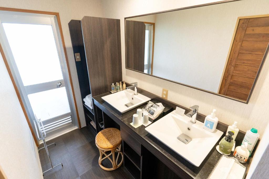 une salle de bain avec deux lavabos et un grand miroir dans l'établissement Nasu Onsen Sanraku, à Nasu