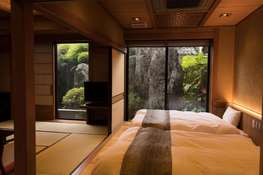 une chambre avec un lit et une grande fenêtre dans l'établissement Beautiful Japanese Garden Kagetsu, à Fuefuki 37 autres photos