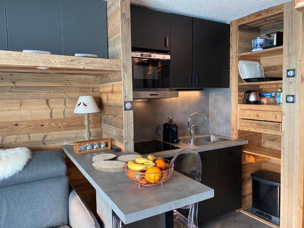 - une cuisine avec un évier et un bol de fruits sur un comptoir dans l'établissement Chalet Olympie, Appartement avec balcon et vue montagne, ski aux pieds, Méribel-Mottaret, à Méribel