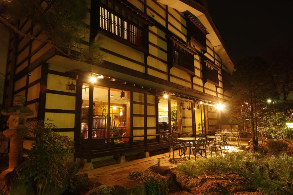- un bâtiment avec une table et des chaises à l'extérieur la nuit dans l'établissement Tsuki no Shizuka, à Matsumoto
