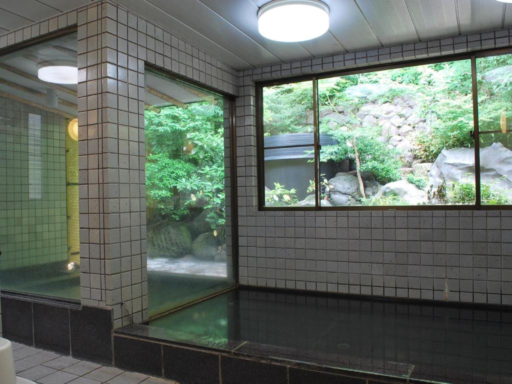 - une salle de bains avec deux fenêtres et une piscine d'eau dans l'établissement Kyo no Minshuku Ohara no Sato, à Kyoto