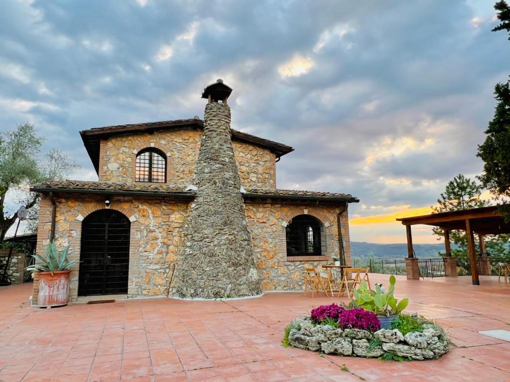 un bâtiment en pierre avec une cheminée sur une terrasse dans l'établissement Casale Delle Querce farmhouse in Giove Umbria with pool, à Giove