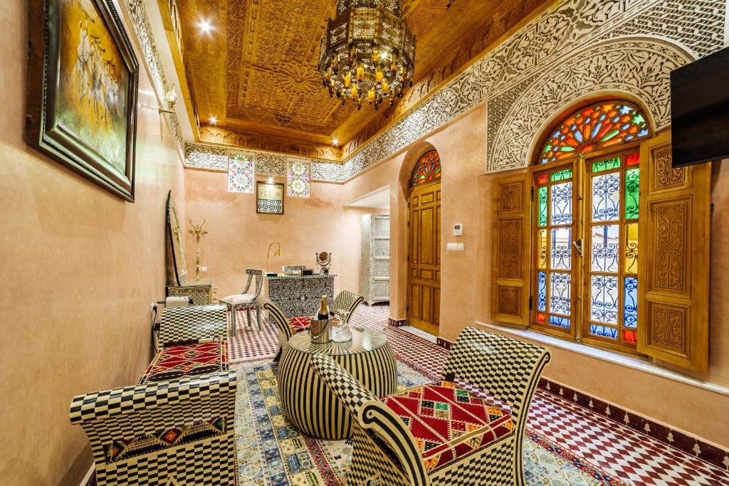 une salle à manger avec une table, des chaises et un lustre dans l'établissement Riad Rcif Alif Suite & SPA, à Fès
