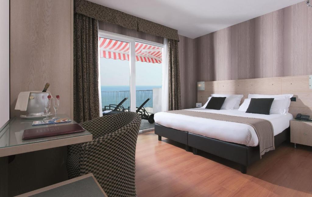 une chambre d'hôtel avec un lit et une grande fenêtre dans l'établissement Victoria Frontemare Beach & Spa Hotel Jesolo, à Lido di Jesolo