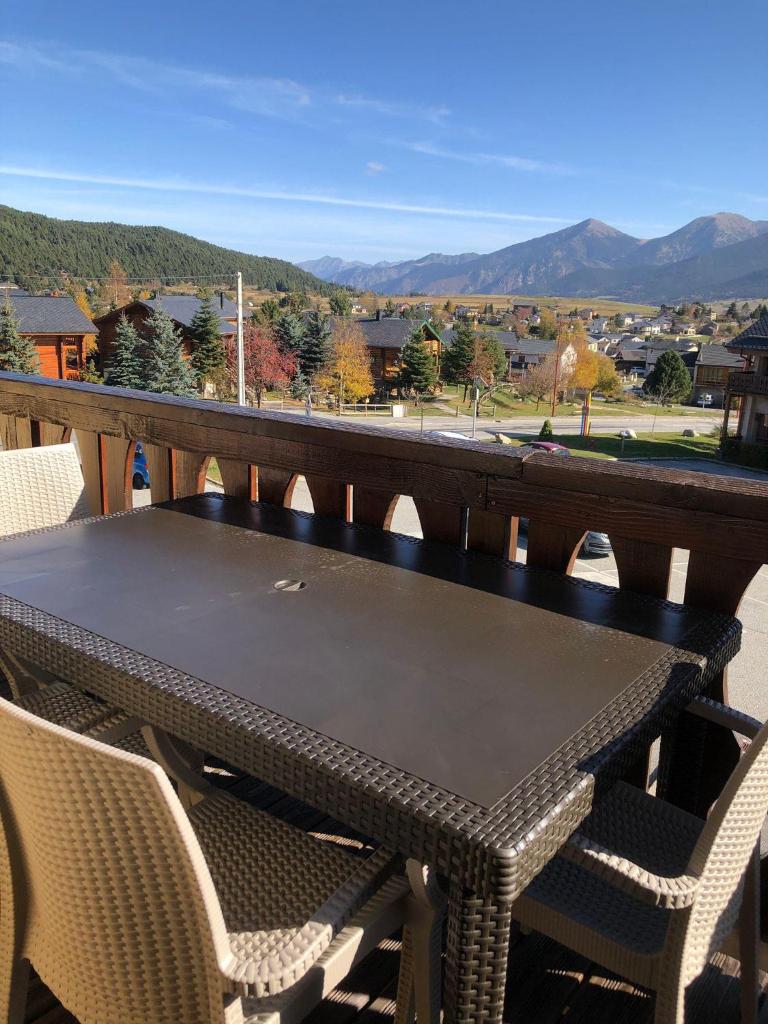 une table et des chaises sur un balcon avec vue dans l'établissement Appartement tout confort - Belle vue sur le Cambre d'Aze, à Bolquère-Pyrénées 2000