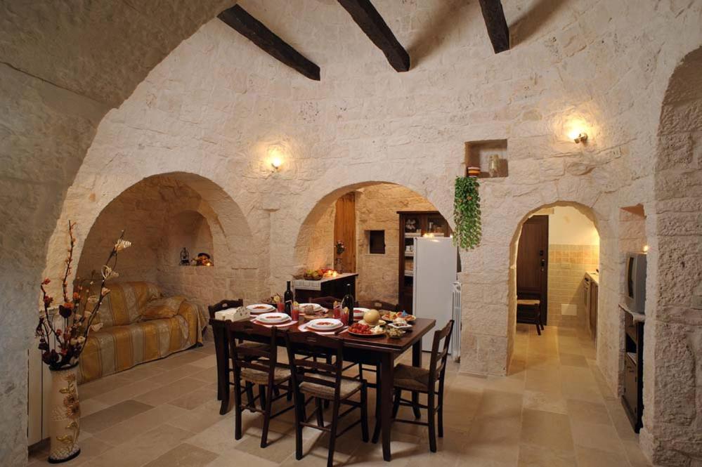 une cuisine et une salle à manger avec une table et des chaises dans l'établissement Trullo Narciso, à Alberobello