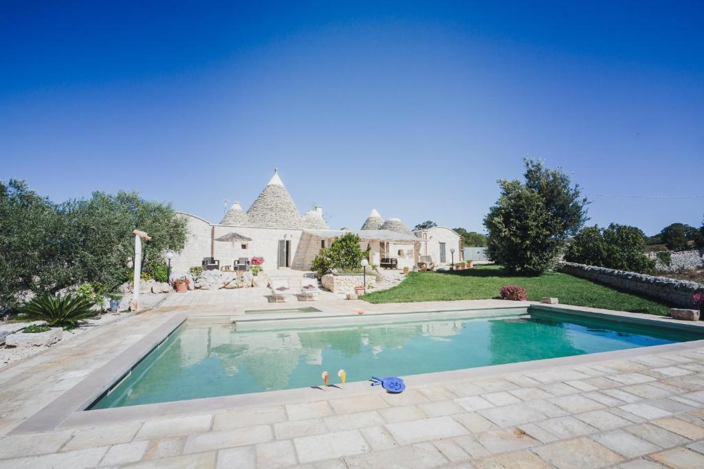une piscine devant une maison dans l'établissement Trullo Narciso, à Alberobello