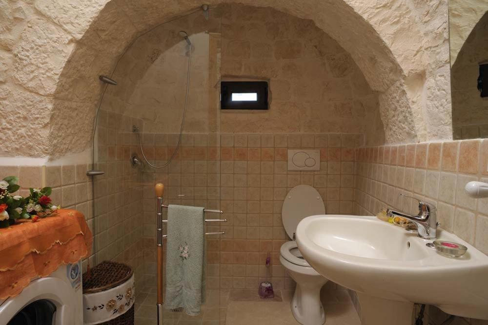 une salle de bain avec une douche, des toilettes et un lavabo dans l'établissement Trullo Narciso, à Alberobello 19 autres photos