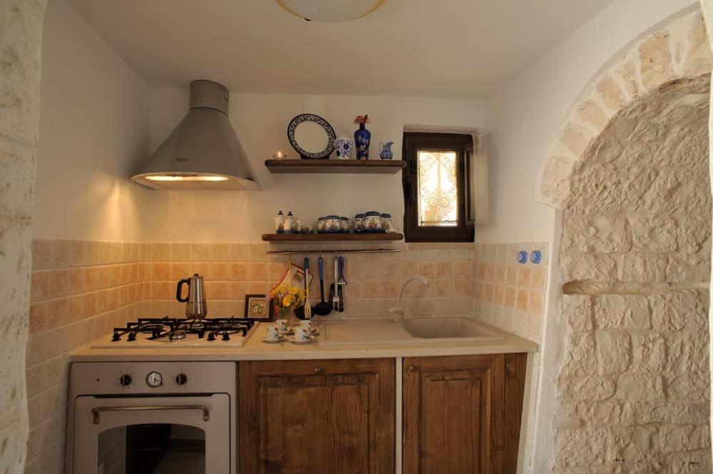 une cuisine avec un évier et une cuisinière four supérieur dans l'établissement Trullo Narciso, à Alberobello