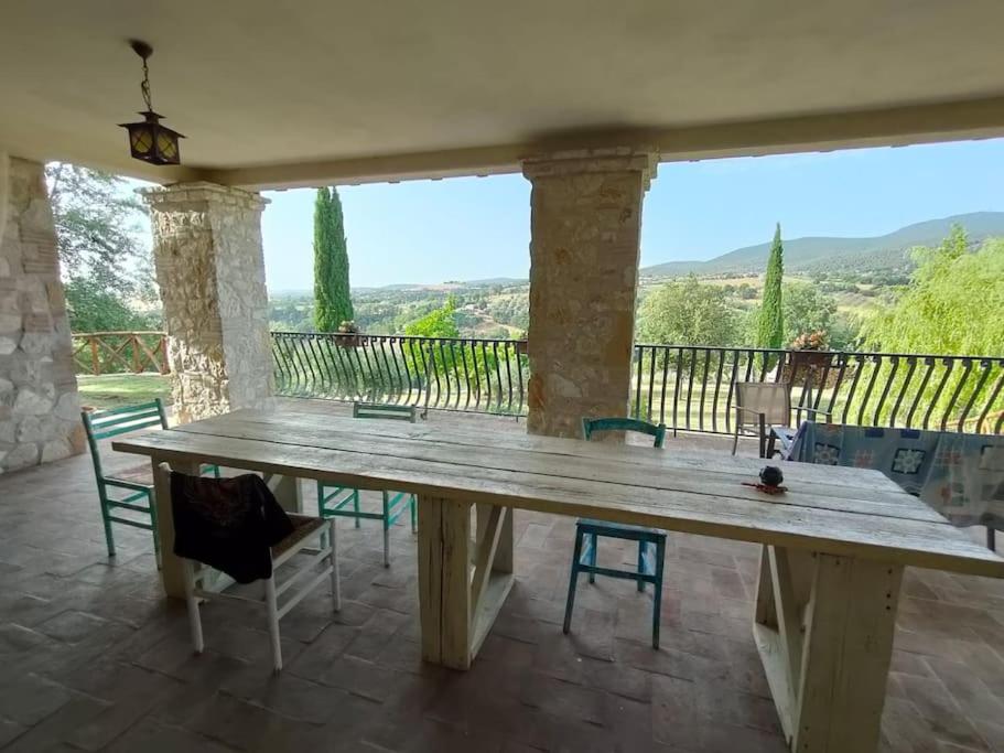 une grande table en bois sur une terrasse avec des chaises dans l'établissement Country House Pacifici, Villa con piscina privata, à Calvi dellʼ Umbria