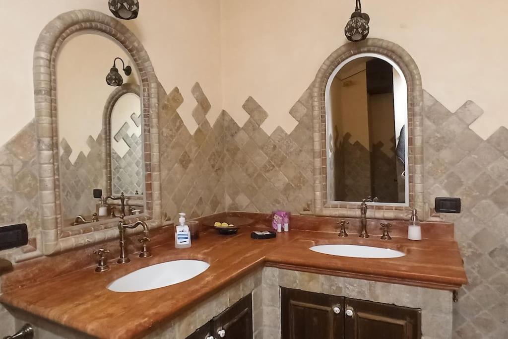 une salle de bain avec deux lavabos et deux miroirs dans l'établissement Country House Pacifici, Villa con piscina privata, à Calvi dellʼ Umbria