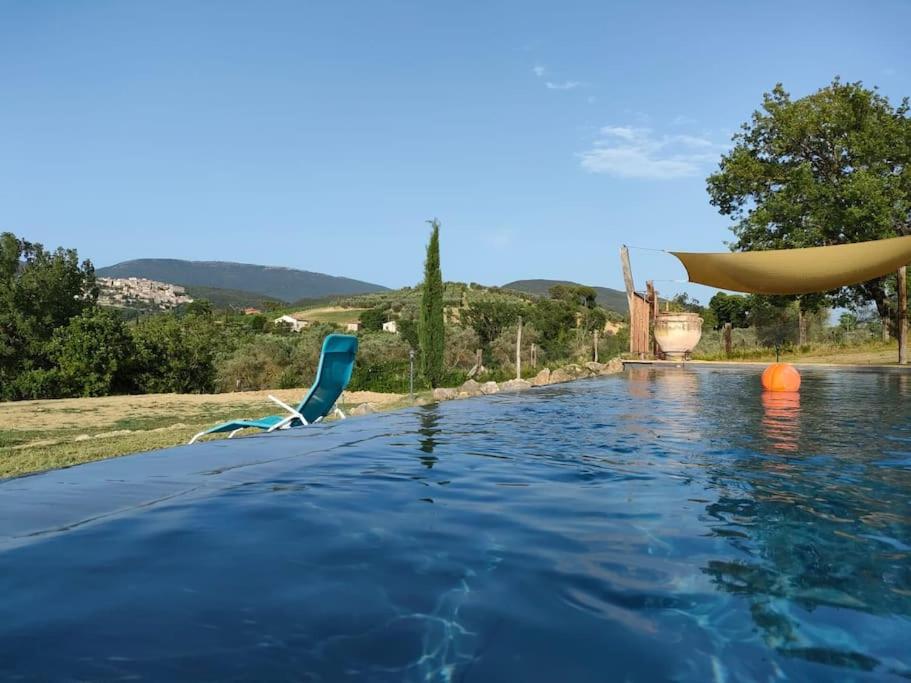 une piscine d'eau avec une chaise et une piscine dans l'établissement Country House Pacifici, Villa con piscina privata, à Calvi dellʼ Umbria