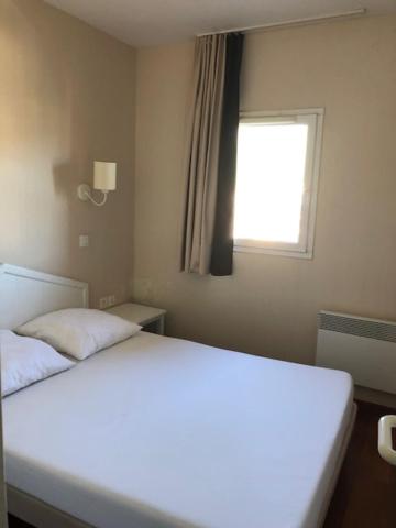 un lit blanc dans une chambre avec une fenêtre dans l'établissement Valmeinier 1800 - T2 pdp - 4ou5 p, à Valmeinier