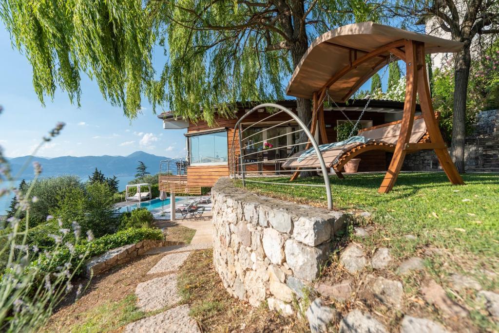 une maison avec un toboggan et un mur en pierre dans l'établissement Villa Vela, à Torri del Benaco