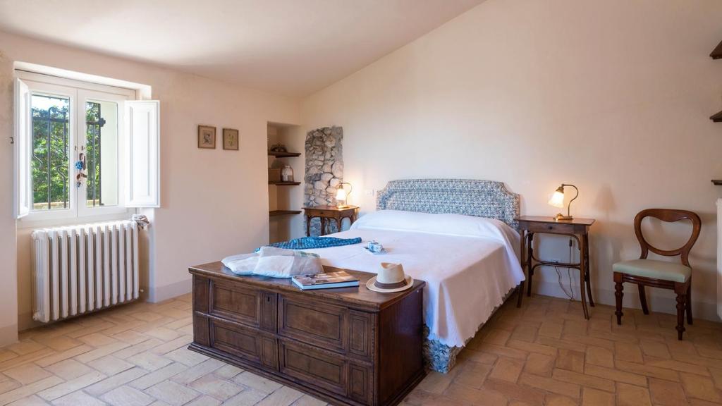une chambre avec un lit, une table et une chaise dans l'établissement LA CASA NEI VIGNETI 10, Emma Villas, à Catignano 41 autres photos