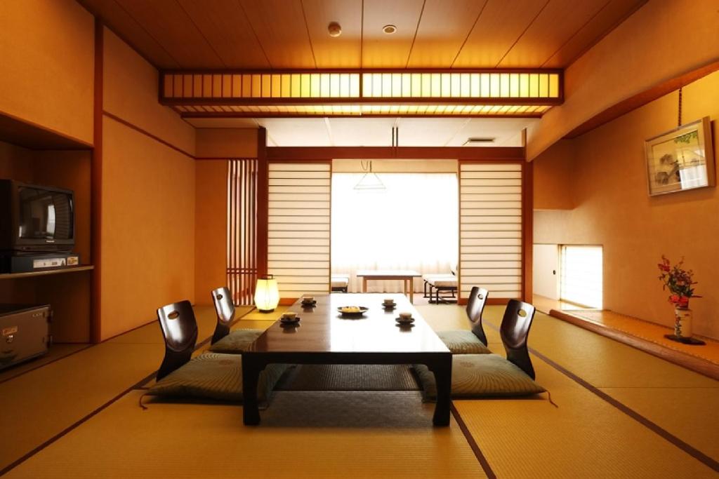 une salle à manger avec une table et des chaises dans l'établissement Yumotoya, à Niigata