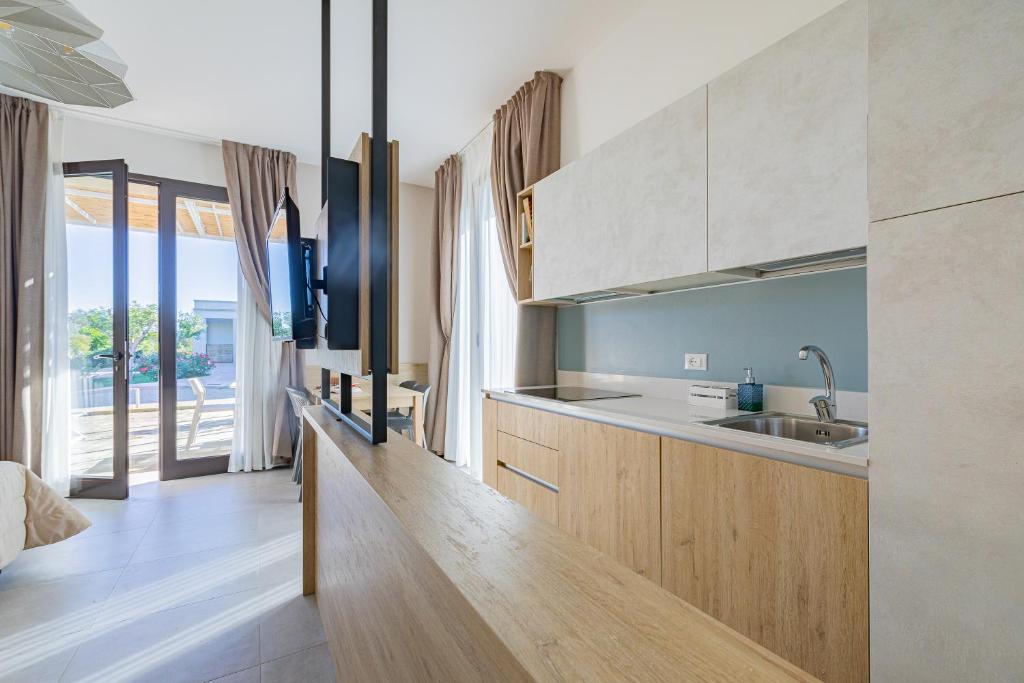 - une cuisine avec des placards en bois et un évier dans la chambre dans l'établissement Agriturismo Vigna Corallo, à Otrante