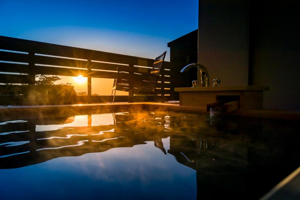 - une piscine au coucher du soleil en arrière-plan dans l'établissement Mayu Futahari, à Nishiizu