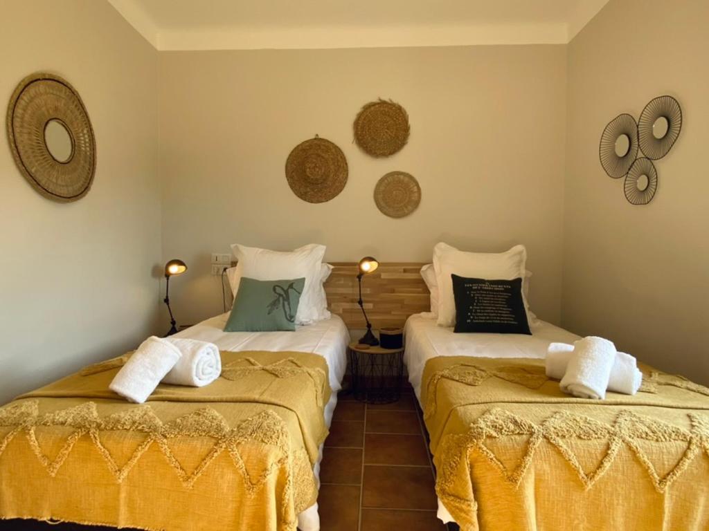 - une chambre avec 2 lits avec des draps jaunes dans l'établissement Mas de Veyras - Gîtes 5 étoiles en Ardèche, à Lachapelle-sous-Aubenas 13 autres photos
