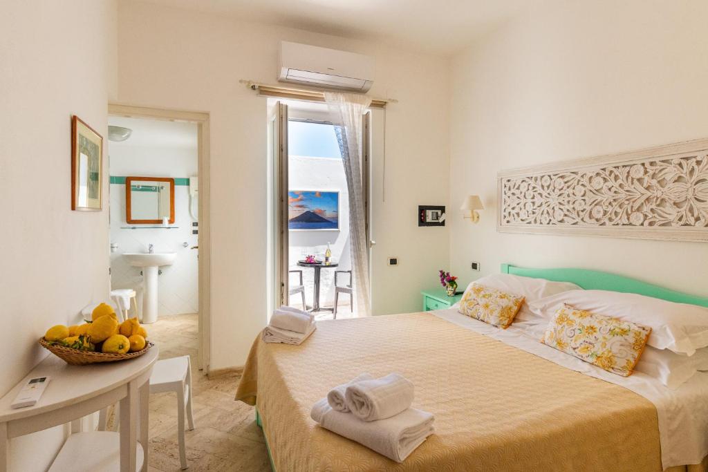 une chambre avec un lit avec une table et une fenêtre dans l'établissement Hotel Ossidiana Stromboli Center, à Stromboli 179 autres photos