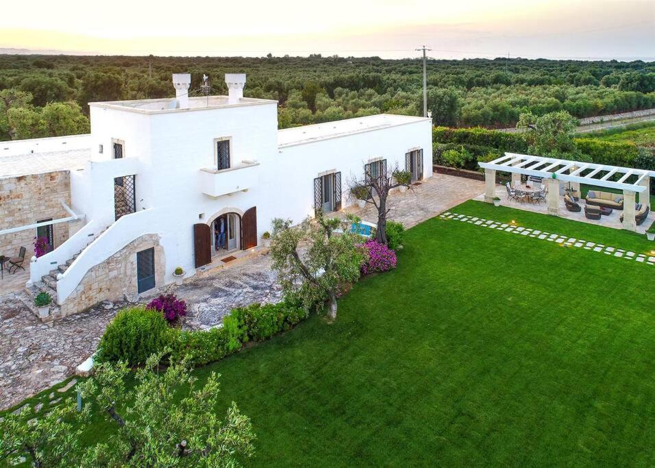 - une vue aérienne sur une maison blanche avec une cour dans l'établissement Masseria Il Frantoio by Raro Villas, à Ostuni