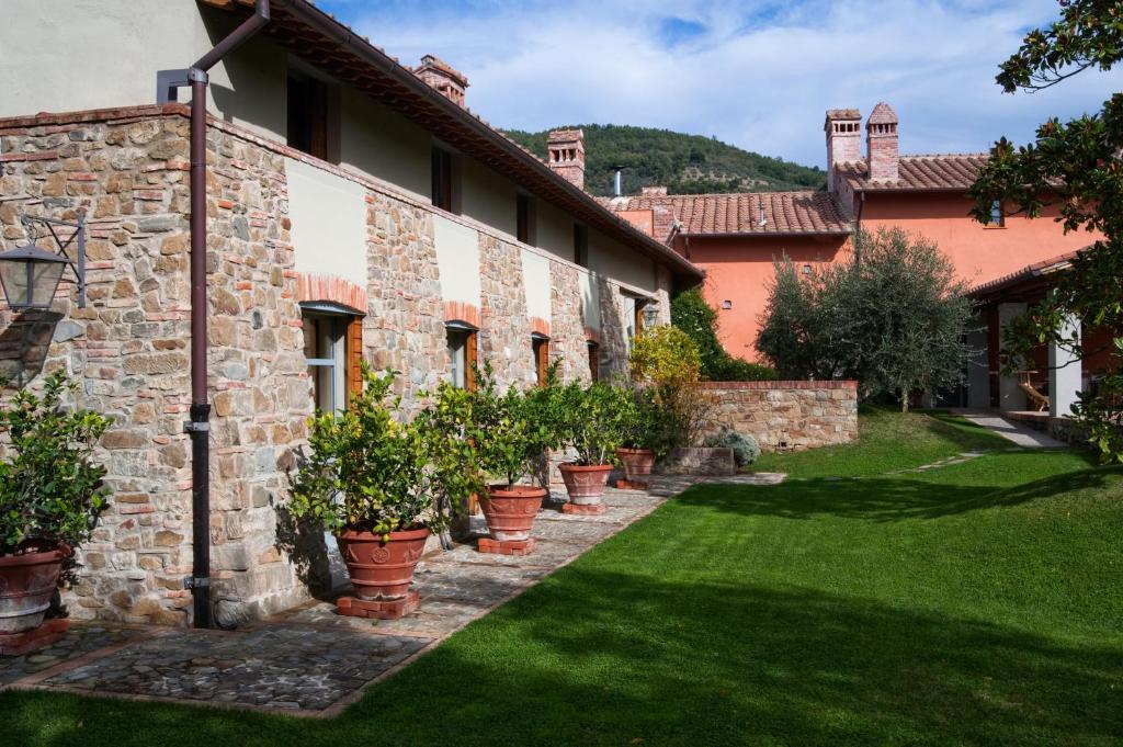 une cour d'un bâtiment avec des plantes en pot dans l'établissement Fattoria Casamora - Villa Le Magnolie, à Pian di Scò
