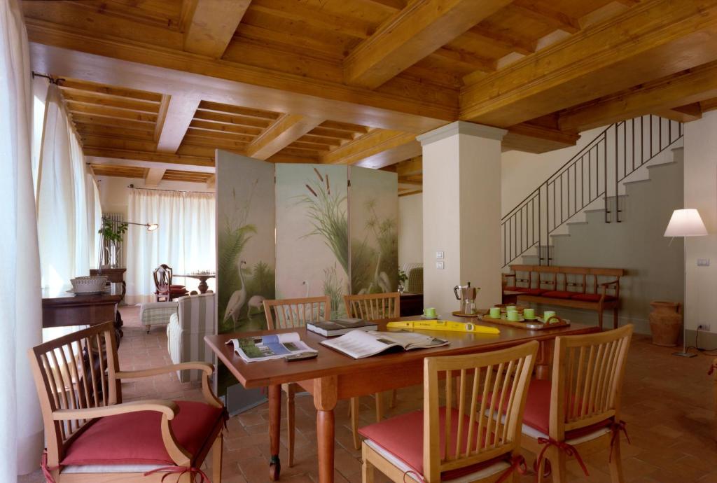 une salle à manger avec une table et des chaises en bois dans l'établissement Fattoria Casamora - Villa Le Magnolie, à Pian di Scò