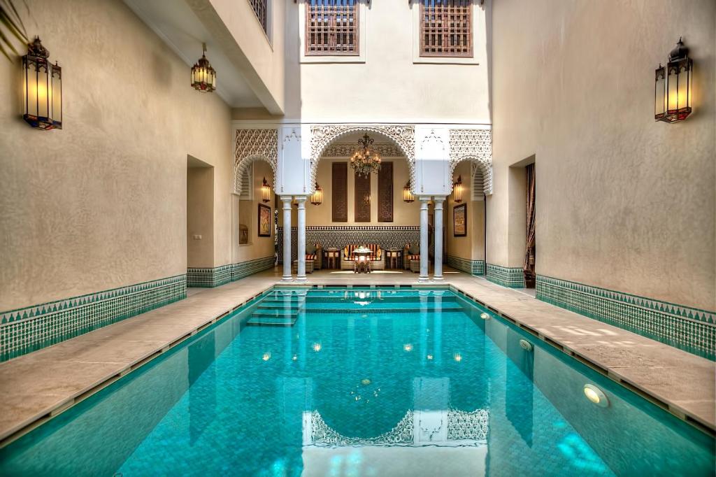 une piscine intérieure dans un bâtiment avec un grand bâtiment dans l'établissement Riad Kniza, à Marrakech