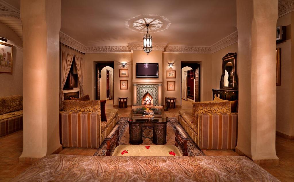 un grand salon avec des canapés et une cheminée dans l'établissement Riad Kniza, à Marrakech