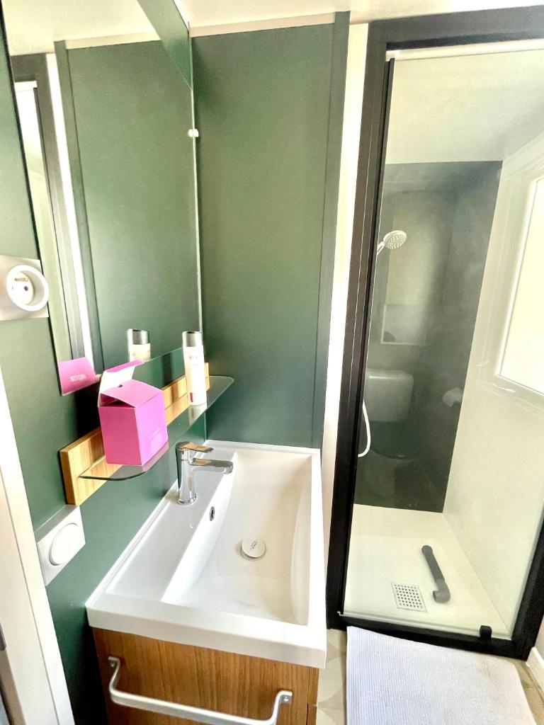 une salle de bain avec un lavabo et une douche dans l'établissement Camping le lac des rêves L'ABRIZEN, à Lattes 10 autres photos