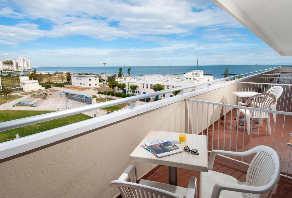 un balcon avec une table et des chaises et l'océan dans l'établissement Hotel Cormoran, à Cattolica