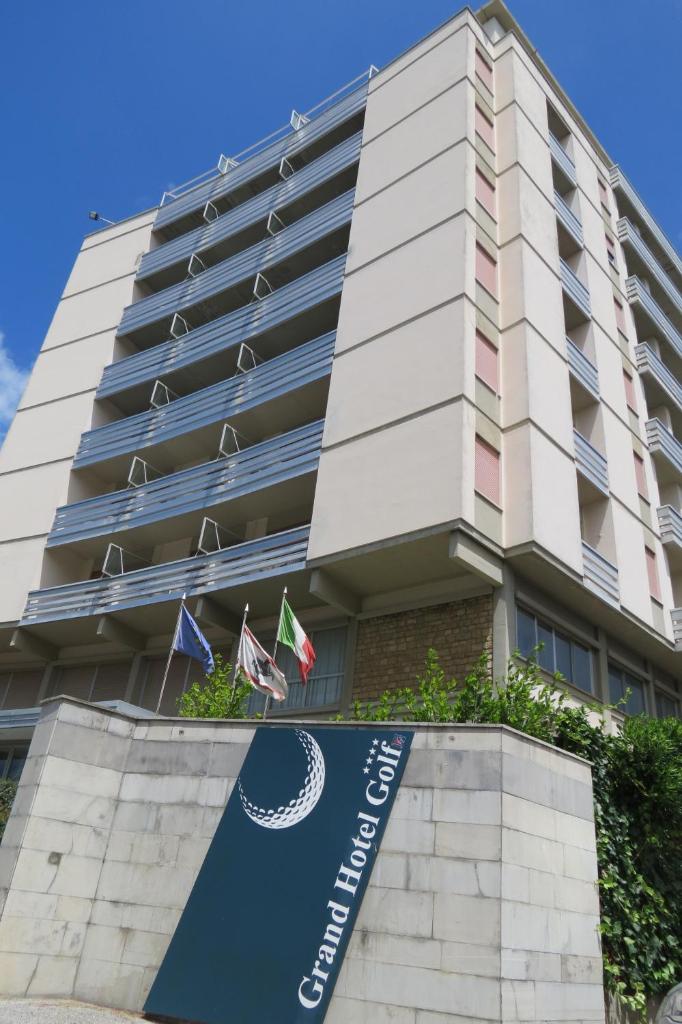 un bâtiment avec une enseigne devant lui dans l'établissement Grand Hotel Golf, à Tirrenia
