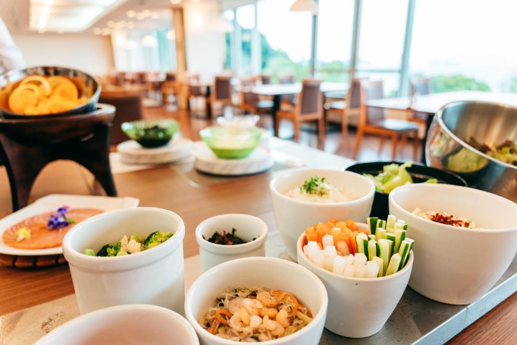 une table recouverte de bols de différents types de denrées alimentaires dans l'établissement KAMENOI HOTEL Setouchi Hikari, à Hikari