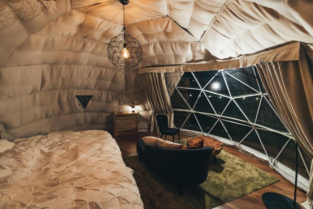 - une chambre avec un grand lit et une chaise dans l'établissement Matsukaneya Annex, à Zao Onsen