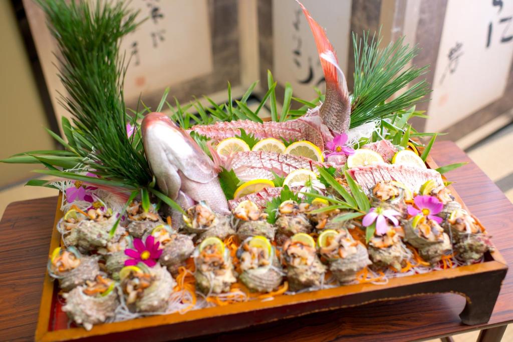 - un plateau de sushis sur une table avec des fleurs dans l'établissement Fukumakan, à Matsue