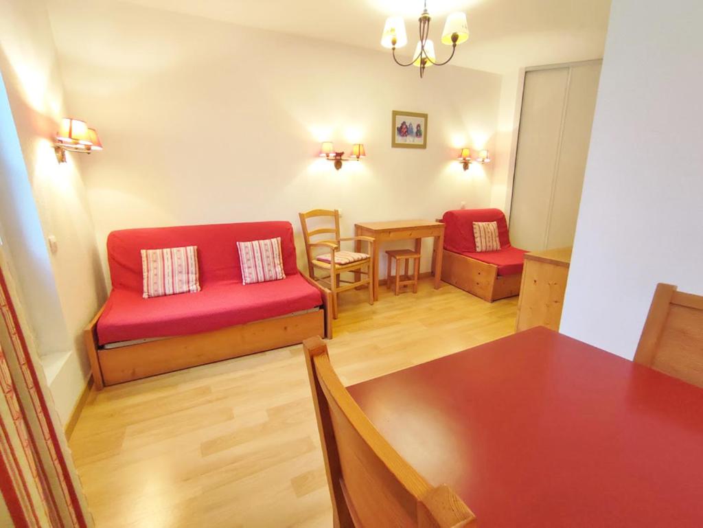 un salon avec un canapé rouge et une table dans l'établissement Le Marmotton, T2, centre Luchon, wifi, casier à skis, ascenseur, 5 personnes, à Luchon 2 autres photos