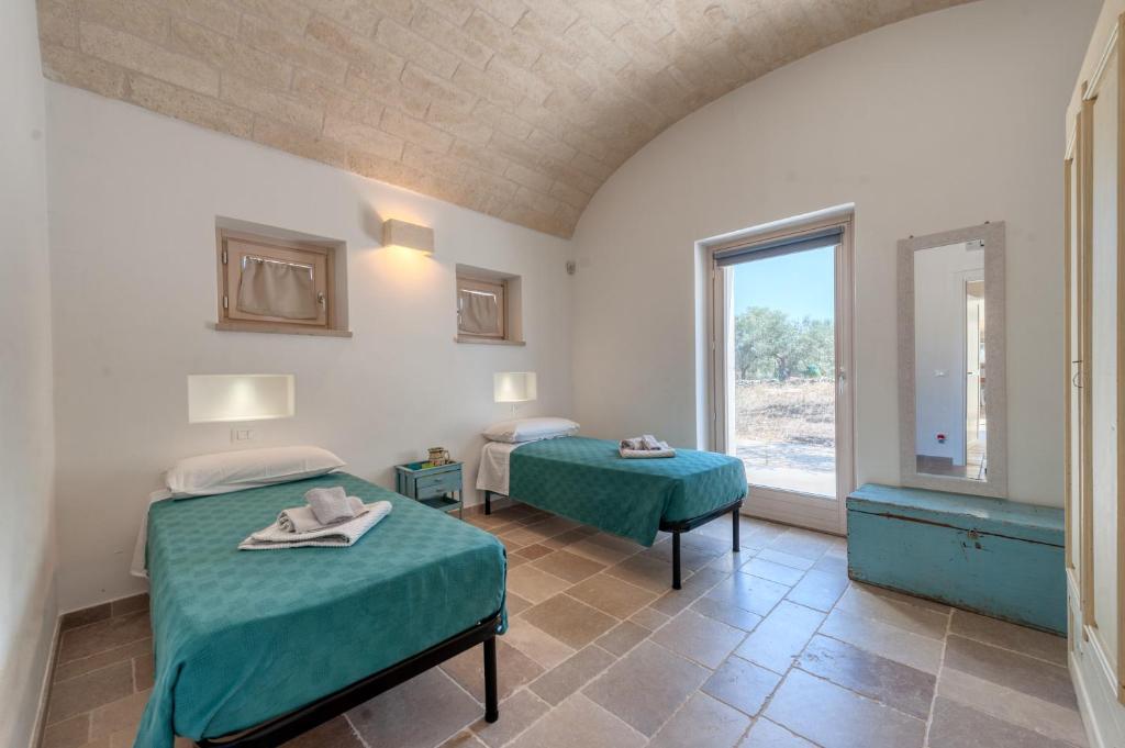 une chambre avec deux lits et une fenêtre dans l'établissement Trullo Amelie, à Ostuni