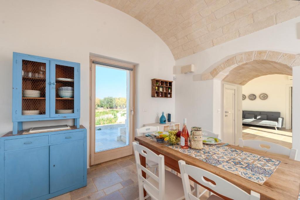 une cuisine avec des armoires bleues et une table dans l'établissement Trullo Amelie, à Ostuni