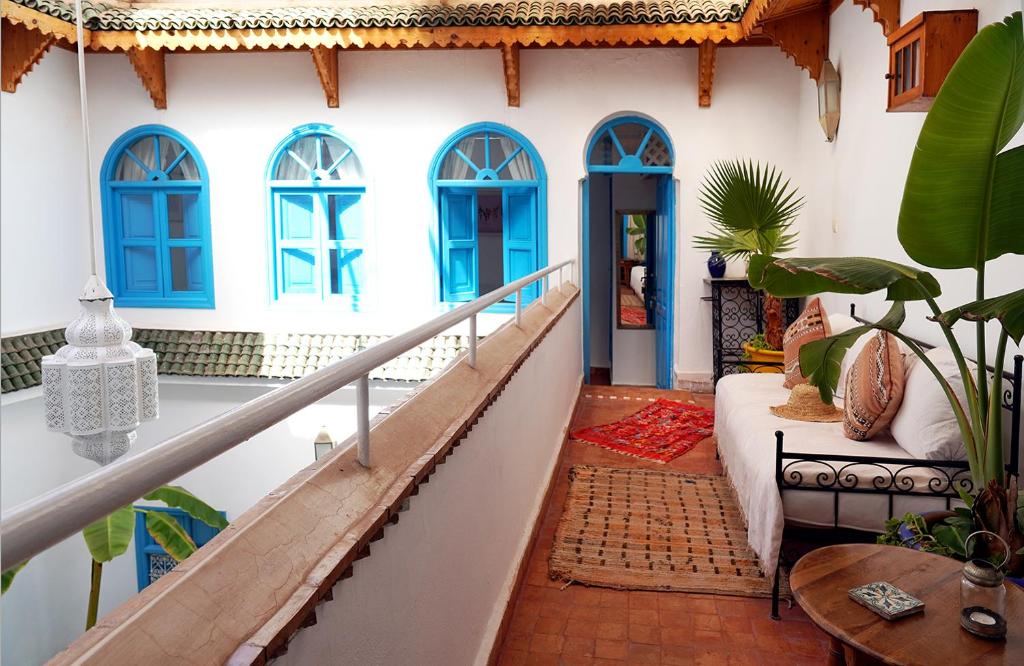 une maison avec des fenêtres bleues et un escalier avec un canapé dans l'établissement Dar Daoud, à Marrakech