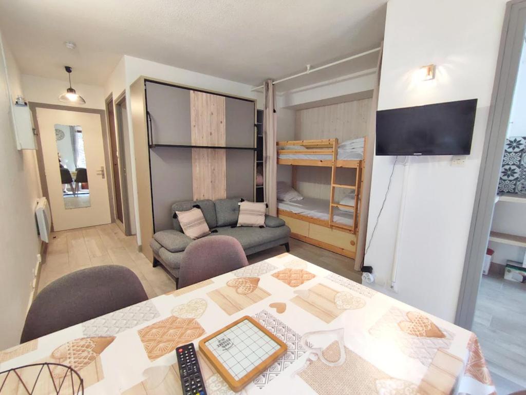 un salon avec une table et un canapé dans l'établissement Le reflet des montagnes, studio, centre Luchon, 4 personnes, à Luchon