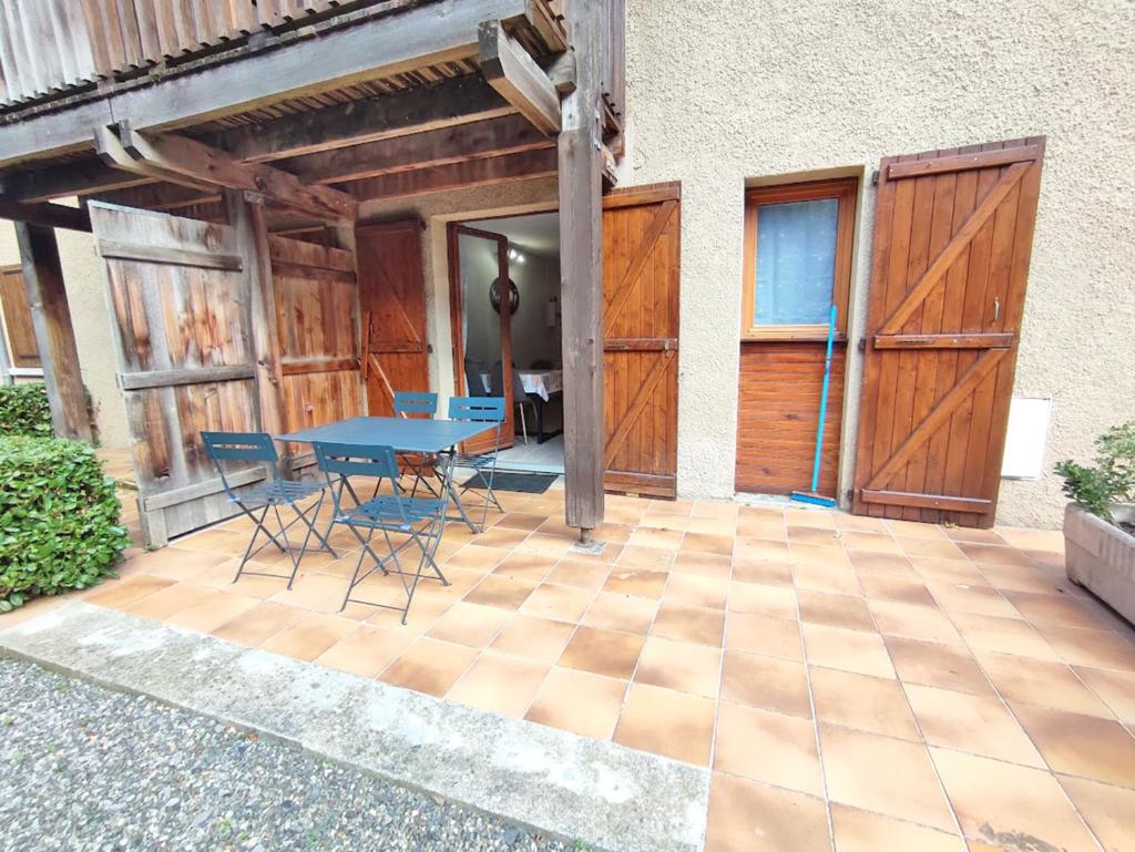 une terrasse avec une table bleue et des chaises. dans l'établissement Le reflet des montagnes, studio, centre Luchon, 4 personnes, à Luchon