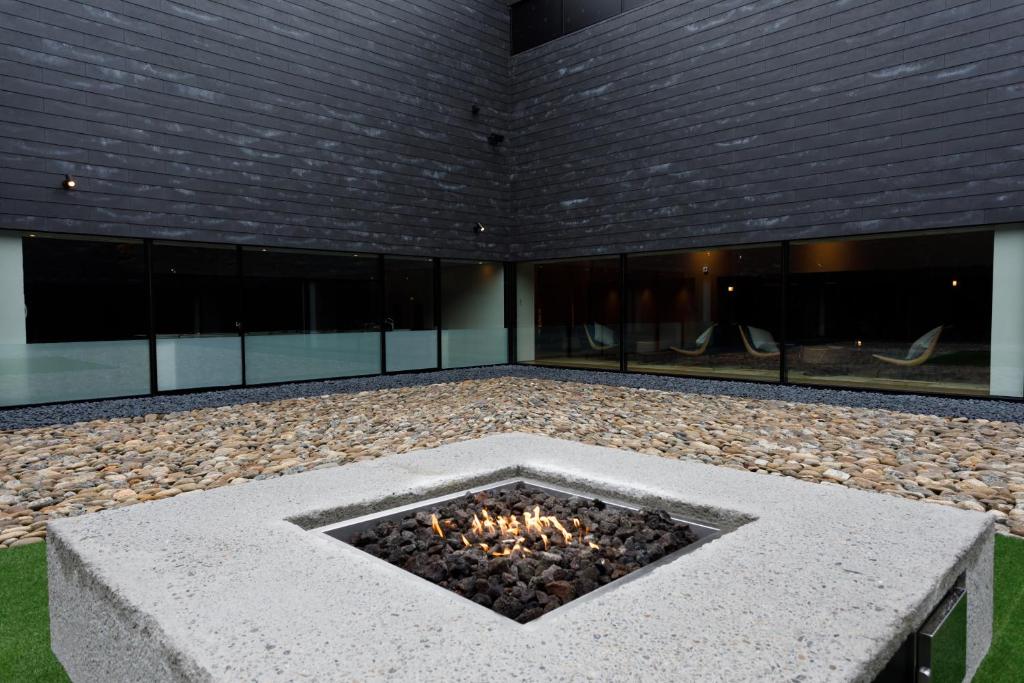 un foyer extérieur au milieu d'un bâtiment dans l'établissement Tokachigawa Moor Onsen Seijyakubow, à Otofuke