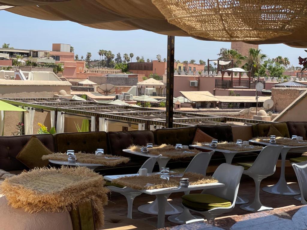 un restaurant avec des tables et des chaises sur le toit dans l'établissement MAISON MK Adults ONLY - Music Riad, à Marrakech
