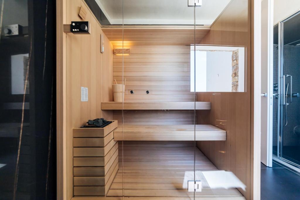 La salle de bains est pourvue de murs en bois et d'une paroi en verre. dans l'établissement Villa Sabrina Riviera dei Fiori a Picco sul Mare con Piscina Privata ,WELLNESS & SPA, à Imperia