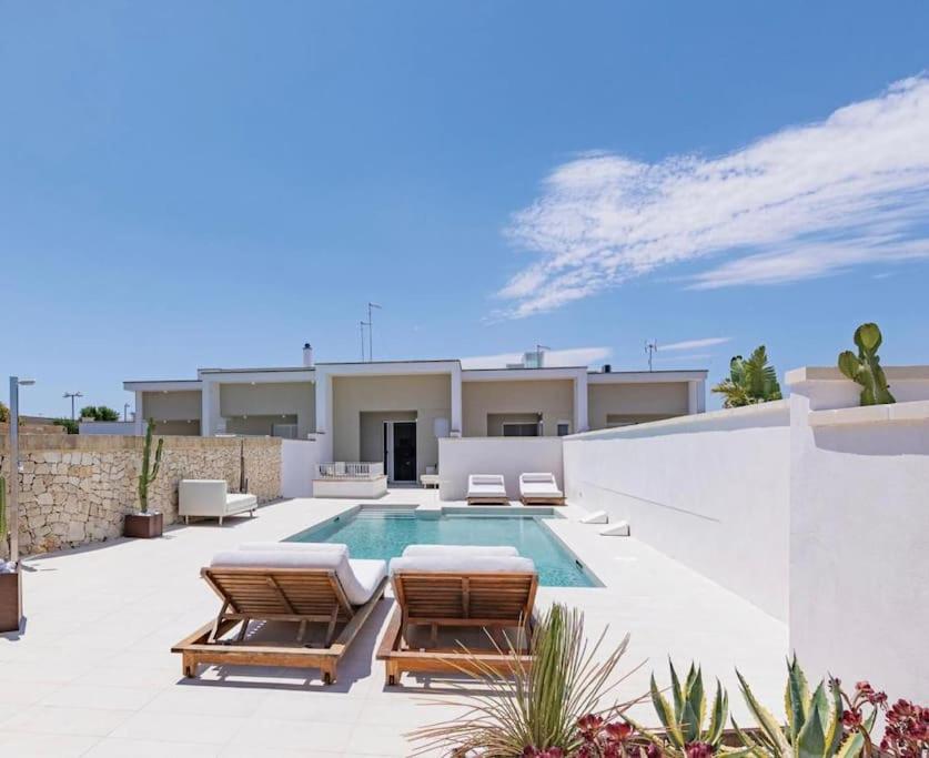 - une piscine avec 2 chaises longues et une maison dans l'établissement Villa Skyline- Otranto, à Otrante