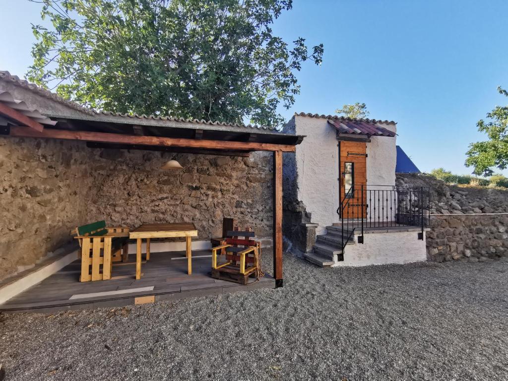 un patio avec une table et des chaises et un bâtiment dans l'établissement Domus Nirale, à Bagnoregio